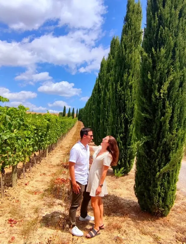 Couple enjoying a private wine tour among vineyards and cypress trees in Tuscany