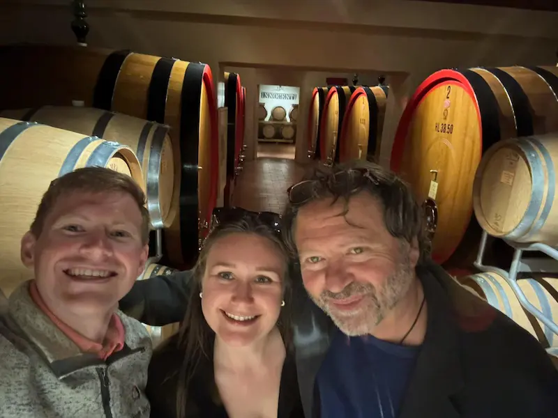 Fabrizio with smiling guests inside a family-owned Tuscan winery