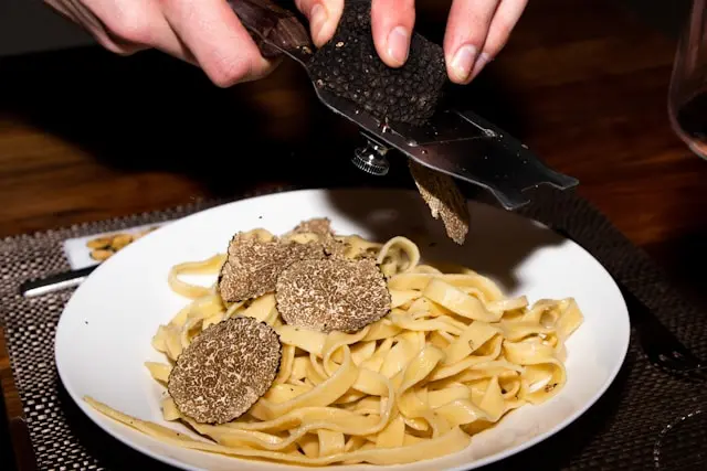 Fresh truffle shaved over handmade pasta during a traditional Tuscan lunch after a private truffle hunt