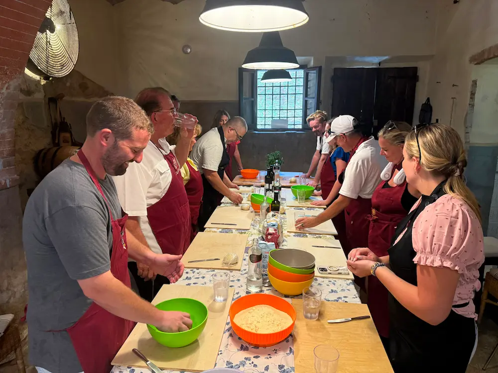 Guests making fresh pasta during a hands-on Tuscan cooking class