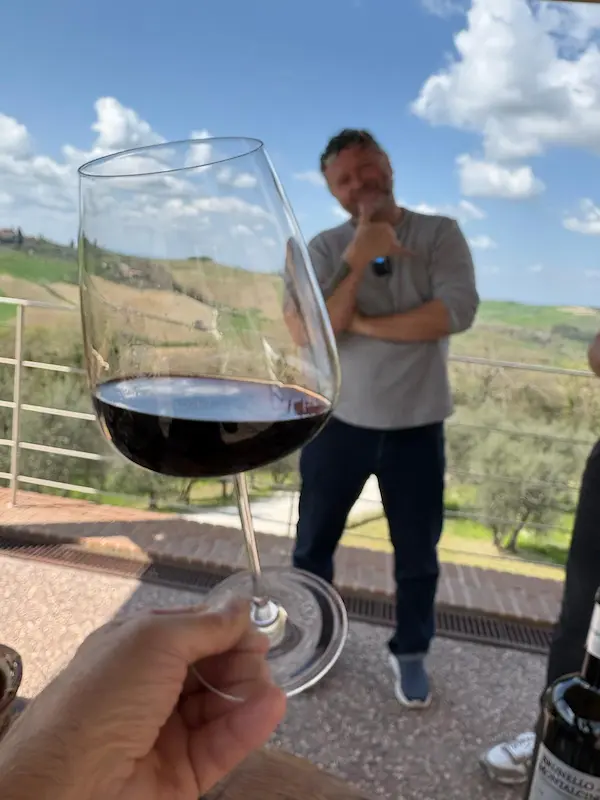 Glass of Tuscan red wine with Fabrizio overlooking the countryside during a private wine experience